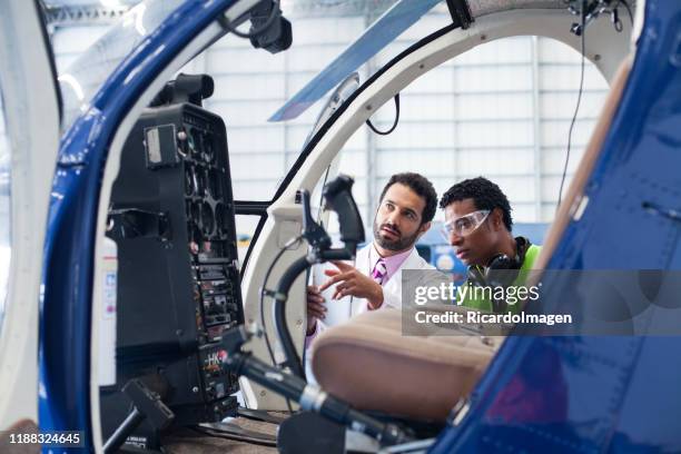 ingenieur geeft de technicus instructies over het werk aan de helikopter te doen - vliegtuigmonteur stockfoto's en -beelden