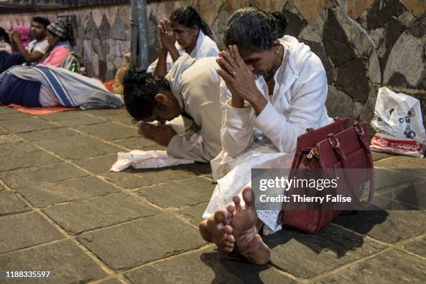 Buddhist pilgrims pray while waiting for the sunrise at the top of Adam's Peak. Adam's Peak is a 2,243 meter conical mountain well known for its...