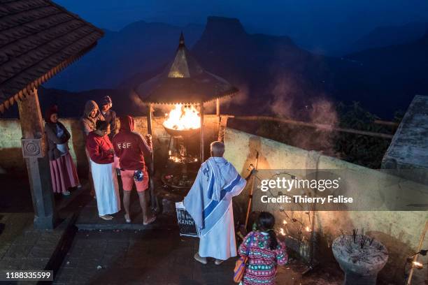 Buddhist pilgrims light candles with blessed oil while waiting for the sunrise at the top of Adam's Peak. Adam's Peak is a 2,243 meter conical...