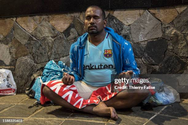 Muslim pilgrim prays while waiting for the sunrise at the top of Adam's Peak. Adam's Peak is a 2,243 meter conical mountain well known for its...