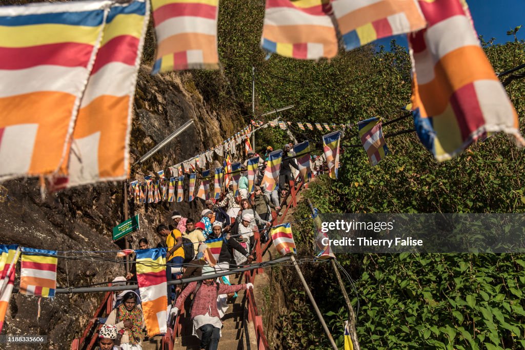 Pilgrims and tourists walk the way down from the top of Adam...