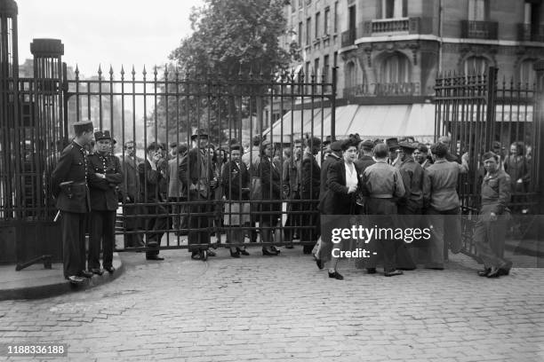 Travelers wait outside the gates of the Gare de l'Est train station, totally closed during the SNCF railway workers' strike, on June 06, 1947 in...