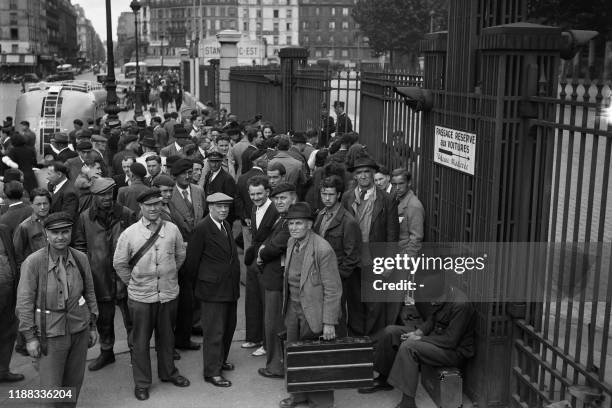 Travelers wait outside the gates of Gare de l'Est train station, totally closed during the SNCF railway workers' strike, on June 06, 1947 in Paris.