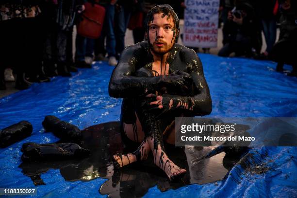 Activists performing with oil during a protest outside IFEMA ,where UN Climate Change Conference COP25 is being held. Fridays for Future and...