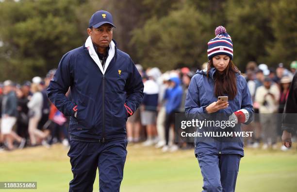 Team captain Tiger Woods and girlfriend Erica Herman follow the players during the third day of the Presidents Cup golf tournament in Melbourne on...