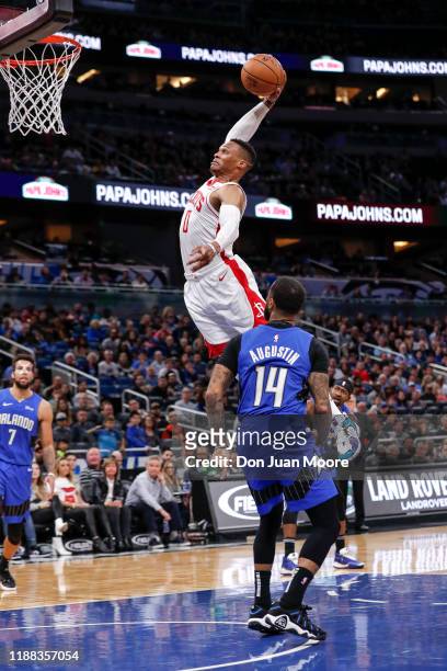 Russell Westbrook of the Houston Rockets goes up for a dunk over D.J. Augustin of the Orlando Magic during the game at the Amway Center on December...