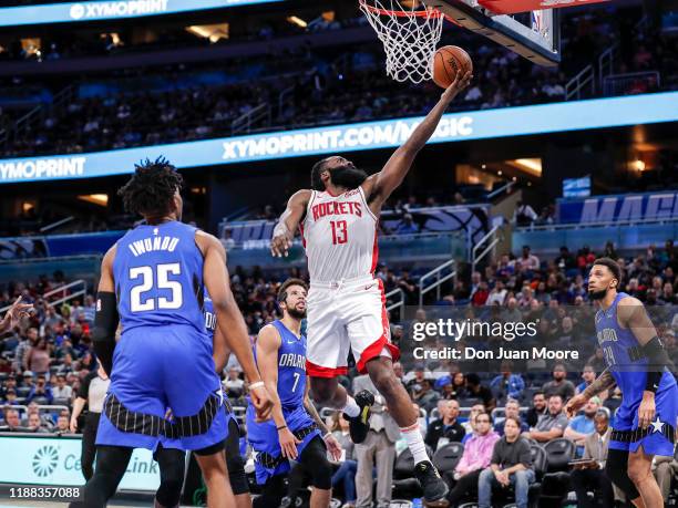 James Harden of the Houston Rockets drives to the basket over Wes Iwundu of the Orlando Magic during the game at the Amway Center on December 13,...
