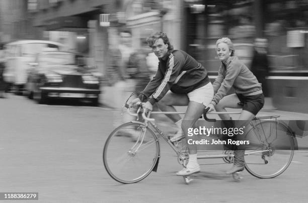 English singer Shirlie Holliman and English actor, director, and musician Martin Kemp driving a tandem bike in Covent Garden, London, UK, 6th June...