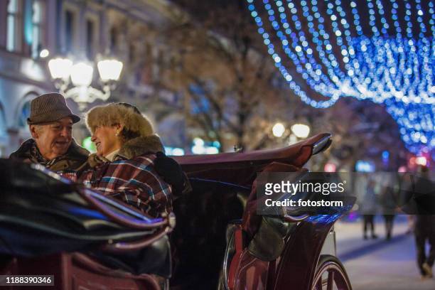 happy senior par på en romantisk chariot rida vid jul - horse carriage bildbanksfoton och bilder