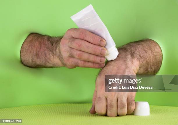 man applying cream with plastic massage tube with 3 roller ball applicator - cream tube stock pictures, royalty-free photos & images