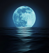 Big Blue Moon Reflected in Dark Water Surface