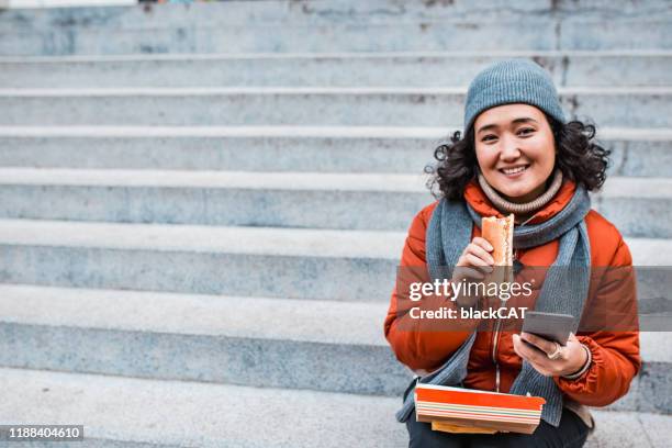 ファーストフードを食べているアジアの女性の肖像 - cat outdoor ストックフォトと画像