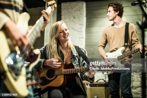 young woman playing acoustic guitar at band rehearsal - rock band shirt stock pictures, royalty-free photos & images