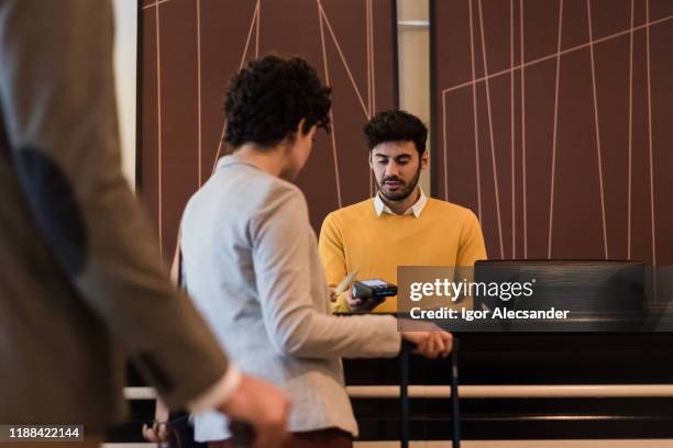 pareja de viajeros que se registra en el hotel - vestíbulo edificio de transporte fotografías e imágenes de stock