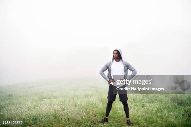 young man standing outdoors in nature after doing exercise, resting. - beautiful hips photos et images de collection
