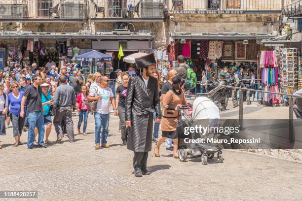 pilgrims walking on a town square at jerusalem old city, israel. - jewish people stock pictures, royalty-free photos & images