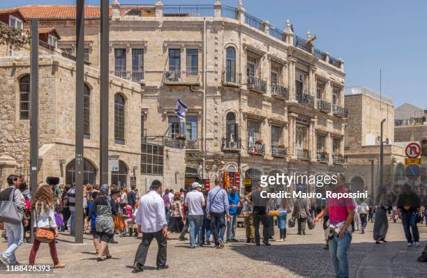 pilgrims walking on a town square at jerusalem old city, israel. - islamic action front stock pictures, royalty-free photos & images