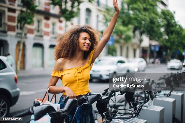 beautiful girl coming back from shopping and greeting someone - curly waves stock pictures, royalty-free photos & images