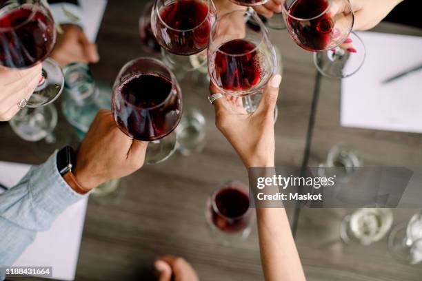 cropped image of businessmen and businesswomen toasting wineglasses over table at convention center - red wine bildbanksfoton och bilder