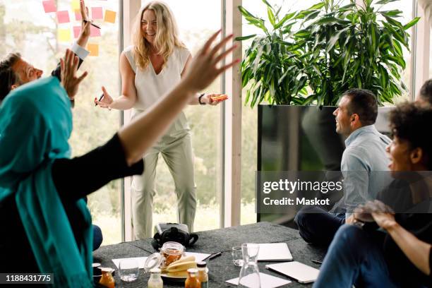 multi-ethnic business professionals cheering during kick off meeting at convention center - team building activity stock pictures, royalty-free photos & images