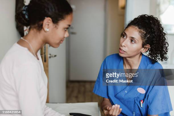 female doctor discussing with patient in medical room at hospital - 女性患者 ストックフォトと画像