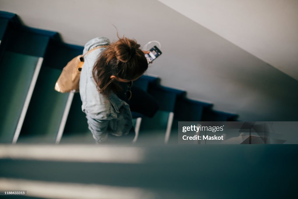 High angle view of woman moving down on stairs in apartment