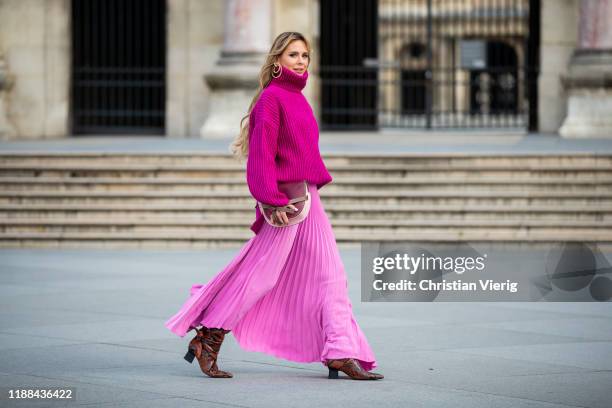 Ekaterina Mamaeva is seen wearing pink turtleneck knit sweater Acne Studios, boots with snake print Rosetta Getty, pink pleated skirt AWAKE Mode,...