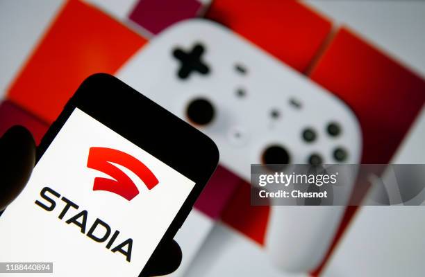 In this photo illustration, the Stadia logo is displayed on the screen of an iPhone in front of a computer screen displaying an advertisement for...