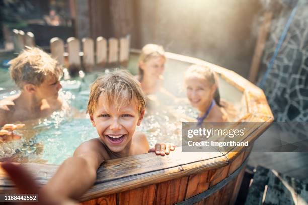 familj njuter vedeldade barrel badtunna på bakgården - varmbadpool bildbanksfoton och bilder