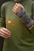 Woman With Sparkler and Contused Hand In Stabilizer