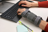 Contused Woman Hand In Stabilizer Working on computer