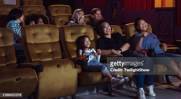 gruppe von menschen, die film im kino mit glück sehen - asian cinema stock-fotos und bilder