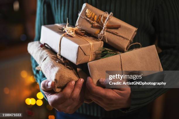 man holding organic christmas presents. - eco packaging stock pictures, royalty-free photos & images