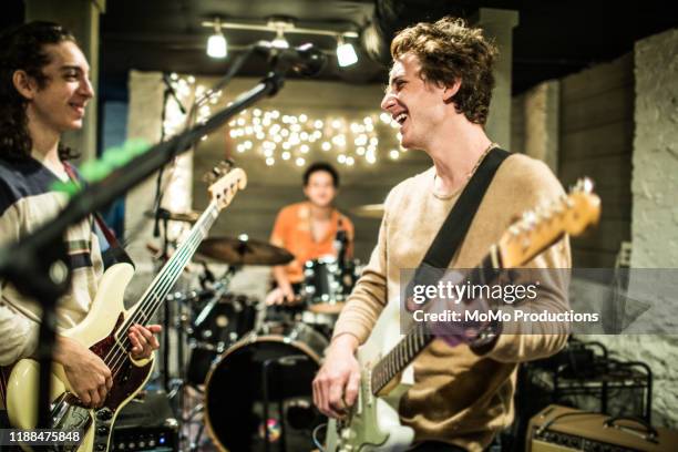 young rock band rehearsing together and laughing - oficios de eventos fotografías e imágenes de stock