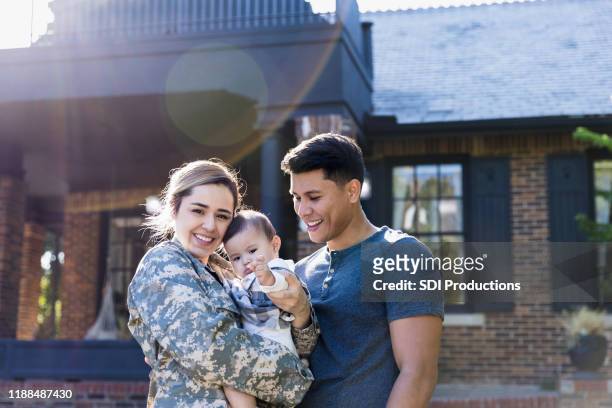 happy female soldier with her family - armed forces stock pictures, royalty-free photos & images