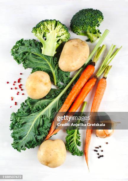 fresh vegetables on white background. potato, kale, carrot, broccoli and onion. - winter vegetables foto e immagini stock