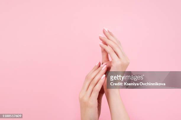 tender hands with perfect blue and pink manicure on trendy pastel pink background. place for text. - manucure photos et images de collection