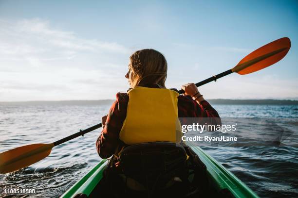woman kayaking on pacific northwest adventure in the puget sound - kayaker woman stock pictures, royalty-free photos & images