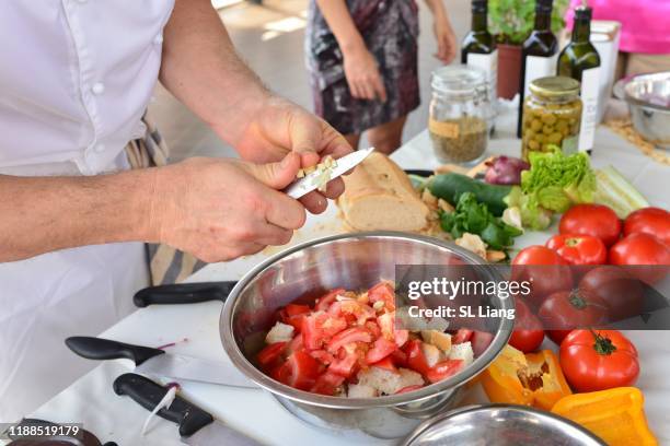 caucasians chef, using parking knife, making salad with tomatoes, bread, beans - butter churn stock pictures, royalty-free photos & images