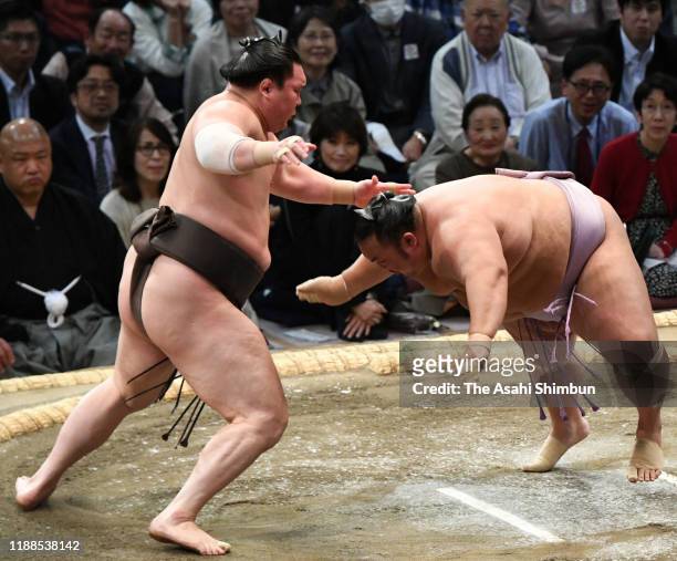 Mongolian yokozuna Hakuho throws Kotoyuki to win on day nine of the Grand Sumo Kyushu Tournament at the Fukuoka Convention Centre on November 18,...