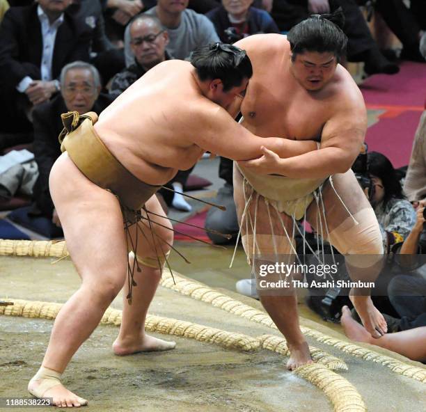 Kagayaki pushes Shimanoumi out of the ring to win on day nine of the Grand Sumo Kyushu Tournament at the Fukuoka Convention Centre on November 18,...