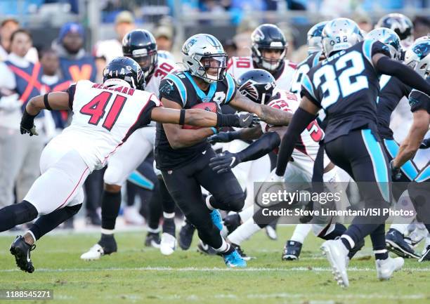 Moore of the Carolina Panthers is tackled by Sharrod Neasman and Jermaine Grace of the Atlanta Falcons during a game between Atlanta Falcons and...