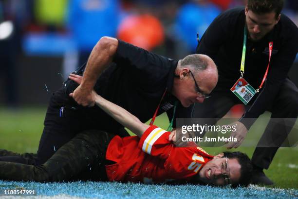 Security holds a fan that invaded the field during the game between the Kansas City Chiefs and the Los Angeles Chargers during the game between the...