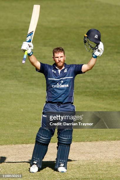Aaron Finch of Victoria raises his bat after scoring 100 runs during the Marsh One Day Cup match between Victoria and South Australia at Melbourne...