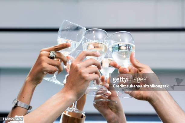 close up of hand  businesspeople ,celebration holding a glass of champagne to celebrate friendship and success in working as a team. - work anniversary stock pictures, royalty-free photos & images