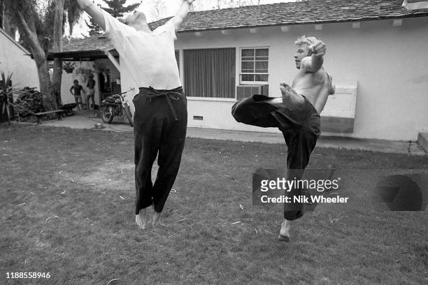 Action hero movie star Chuck Norris practices kung fu style moves with his trainer on the lawn of his back yard of his home in Palos Verdes near Los...