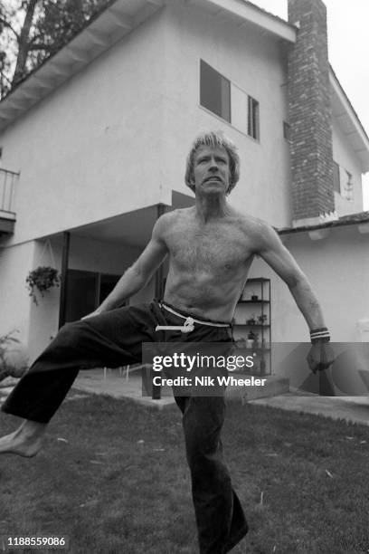 Action hero movie actor Chuck Norris strips down to practice some kung fu style moves barefoot and bare chested in the back yard of his home in Palos...