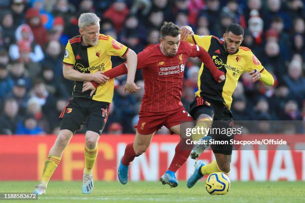 Xherdan Shaqiri of Liverpool battles with Will Hughes of Watford and Etienne Capoue of Watford during the Premier League match between Liverpool FC...