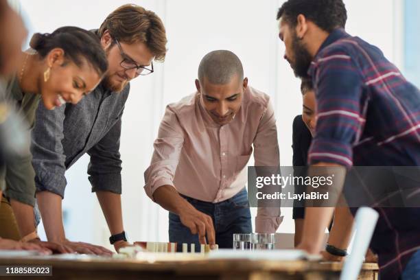 merging their talents and skills to conquer the business game - dominoes stock pictures, royalty-free photos & images