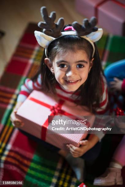 cute girl holding christmas present. - luxury lounges stock pictures, royalty-free photos & images